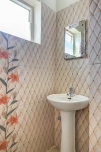 a bathroom with a sink and a mirror at Atithi Comforts in Kushālnagar +56 photos