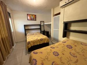two beds in a small room with two beds at Hotel Luxi in Playa Azul