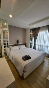 a bedroom with a large white bed with shoes on it at The Patio See Sea 155 in Ban Bang Saen (1) +8 photos