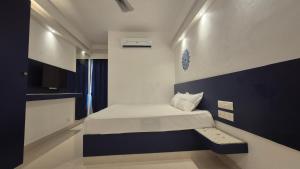a small room with a bed and a bench in it at BLEU by NIRVANA in Mahabalipuram