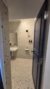 a bathroom with a toilet and a sink and a door at BLEU by NIRVANA in Mahabalipuram