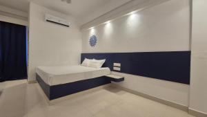 a bedroom with a bed with a blue and white wall at BLEU by NIRVANA in Mahabalipuram