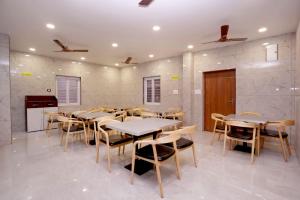 a dining room with tables and chairs and a piano at HOTEL AIKAA in Hyderabad