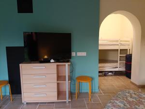 a bedroom with a tv and a dresser and a bed at LeBoisDieu in Thizy-les-Bourgs
