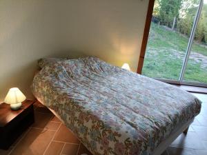 a bedroom with a bed and a large window at LeBoisDieu in Thizy-les-Bourgs