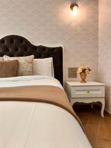 a bedroom with a large bed and a nightstand with a side table at Palazzo De La Sengle Boutique Hotel in Senglea +43 photos
