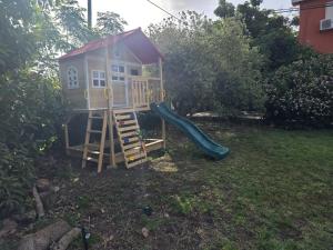 a play house with a slide in a yard at Arbel Guest House Shavit Family in Arbel