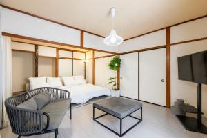 a bedroom with a bed and a tv and a couch at gently stay Nagoya in Nagoya