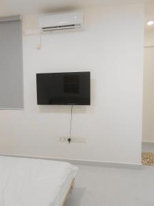 a tv on a white wall in a room at Bougainvillea Breeze in Male City