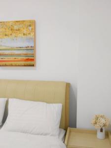 a bedroom with a bed and a painting on the wall at Bougainvillea Breeze in Male City +1 photo
