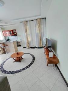 a living room with a table and a television at Keirwa in Kampala