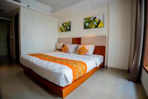a bedroom with a large bed with an orange blanket at Bali Sun Tropical Hotel & Spa - formerly The Sun Hotel & Spa Legian in Legian