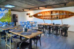 a restaurant with tables and chairs and a boat on the wall at Pike Inn Bucătărie Autentică & Cazare cu Farmec in Dunavăţu de Sus