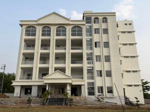 a large white building with large windows at Harsh Pushp Garden in Raipur