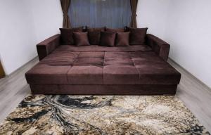 a large brown couch in a room with a rug at Casa Vatra Dornei in Vatra Dornei
