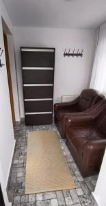 a living room with a leather couch and a door at Casa Vatra Dornei in Vatra Dornei +12 photos