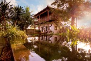 a house with a pond in front of it at Dontrei Villa Angkor in Siem Reap