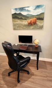 a desk with a computer and a chair in a room at The fancy Shanty in Pilot Hill
