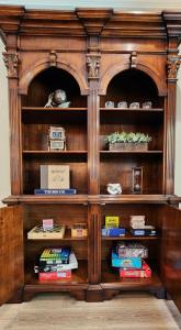 a wooden book shelf with books on it at The fancy Shanty in Pilot Hill