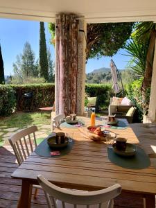a wooden table with plates of food on it at Appartement Premium Genius - Chambre séparée -vue Mer -Jardin Clôturé -Terrasse -Parking - Piscine Chauffée du 04 Avril au 01 Novembre- Saint Raphaël in Agay - Saint Raphael