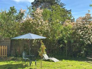 a table and an umbrella in a yard at Le Cerisier in Giverny