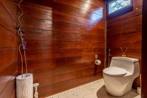 a bathroom with a toilet in a wooden wall at Hidden Paradise West Sumbawa Yo Yos in Sekongkang Bawa +33 photos