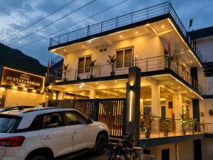 a white car parked in front of a building at Hotel Suryavansham in Gupta Kāshi