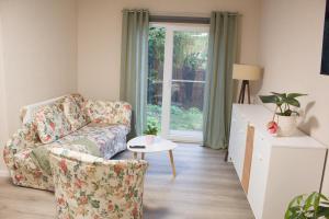 a living room with a couch and a chair and a window at Dahlmanns Pension am Park in Oranienbaum-Wörlitz