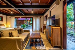 a living room with a couch and a tv at Hidden Paradise West Sumbawa Yo Yos in Sekongkang Bawa