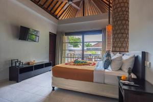 a bedroom with a large bed and a balcony at Bali Mystique Hotel & Apartment Seminyak in Seminyak