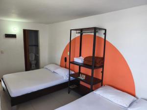 two beds in a room with an orange circle at Hotel Cielo de Tambores in Cali