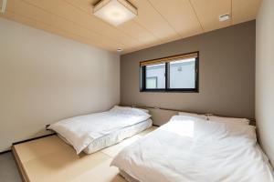 two beds in a room with a window at Forest Resort Walnut in Hakuba +47 photos