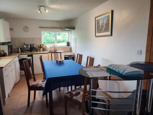 a kitchen with a blue table and chairs at La Maison Bleue23 in Sardent