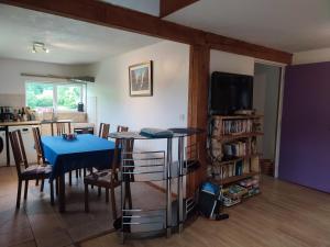 a living room with a blue table and a tv at La Maison Bleue23 in Sardent