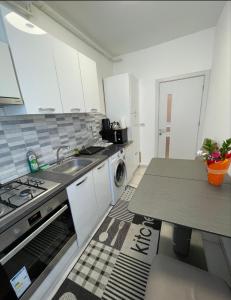 a kitchen with a sink and a stove top oven at Apartament cu 2 camere decomandate in Roşu