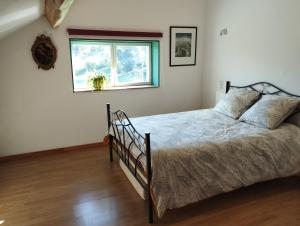 a bedroom with a bed and a window at La Maison Bleue23 in Sardent