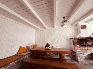 a porch with a wooden table and a fireplace at Casa Crystallia in Chalkida