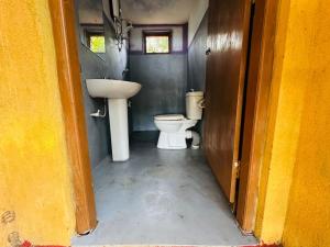a bathroom with a sink and a toilet at Eco Tree House Yala in Tissamaharama
