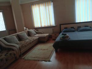 a living room with a bed and a couch at Абай2 103 in Astana