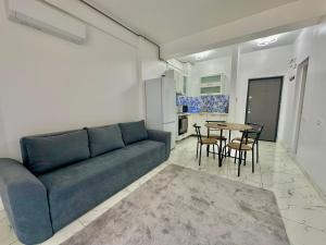 a living room with a blue couch and a table at Marina Evo Apartments in Mamaia Sat/Năvodari