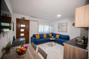 a living room with a blue couch and a table at Aegean View Summer House 1 in Nea Kallikrateia