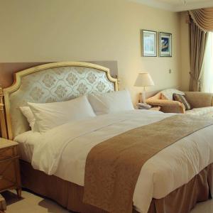 a bedroom with a large bed and a chair at Hotel Galaxy in Mundarwa