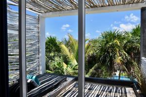 a balcony with a view of the palm trees at TULUM Beachfront Villa Kiin in Tulum +44 photos