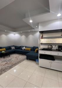 a living room with a blue couch in a room at شقق نرمادا المفروشة فرع قباء in Medina