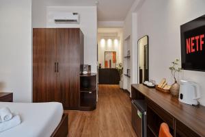 a hotel room with a bed and a wooden counter at V Living - Downtown Saigon Stay with Free Laundry in Ho Chi Minh City