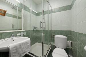 a bathroom with a toilet and a sink and a shower at Boulevard City Panzió - self check-in in Budapest