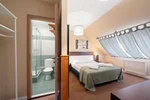 a bedroom with a bed and a bathroom at Boulevard City Panzió - self check-in in Budapest