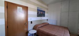 a small bedroom with a bed and a door at Affittacamere Dal Falco in Pienza