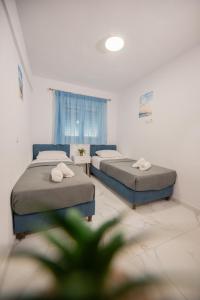 a room with two beds and a window at Aegean View Summer House 1 in Nea Kallikrateia