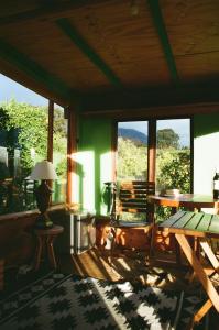 a living room with a table and chairs and windows at Waterfall Farm Self-Catering Cottages Citrusdal in Citrusdal